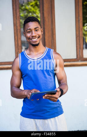 Smiling athletic man using tablet computer Stock Photo