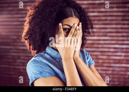 Attractive young woman hiding behind hands Stock Photo