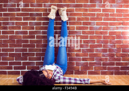 Attractive hipster lying on ground and holding legs up Stock Photo