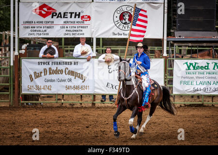 Cowgirl with a American flag at the opening ceremony of a rodeo, Philomath Frolic & Rodeo, Oregon, USA Stock Photo