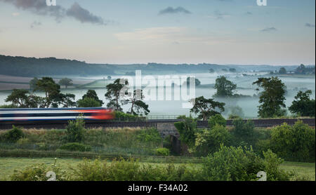 the London Waterloo to Exeter train passing Milborne Wick on a misty summer's morning, Somerset, England, UK