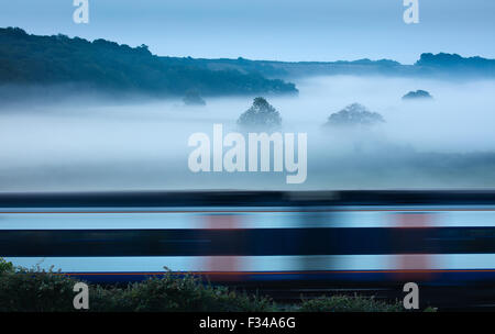 a train passing on a misty morning near Milborne Wick, Somerset, England, UK Stock Photo