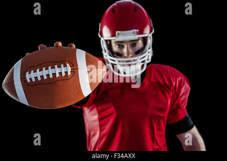 Portrait of american football player showing football to camera Stock Photo