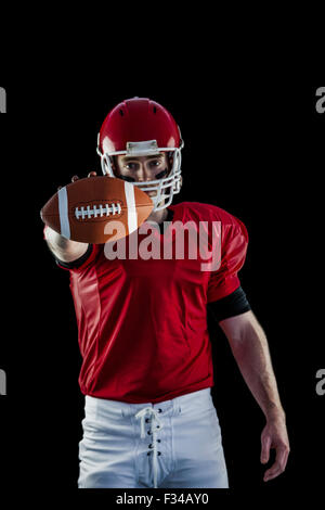 Portrait of american football player showing football to camera Stock Photo