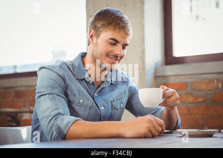 Handsome man smiling and drinking coffee Stock Photo
