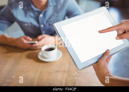Smiling waitress using tablet pc Stock Photo