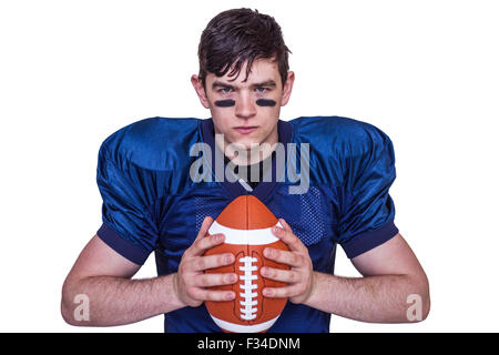 Determined american football player holding a ball Stock Photo