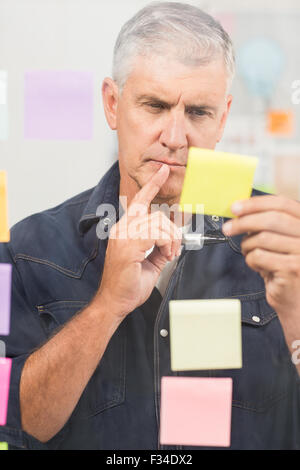 Casual businessman writing on post its Stock Photo