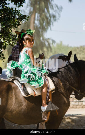 Young girl in traditional dress, horseriding, catholic pilgrimage, romeria Virgen del Rosario, Fuengirola, Andalusia, Spain. Stock Photo