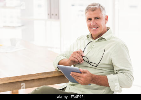 Smiling businessman holding a tablet Stock Photo