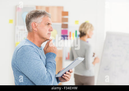 Thoughtful businessman holding a digital tablet Stock Photo