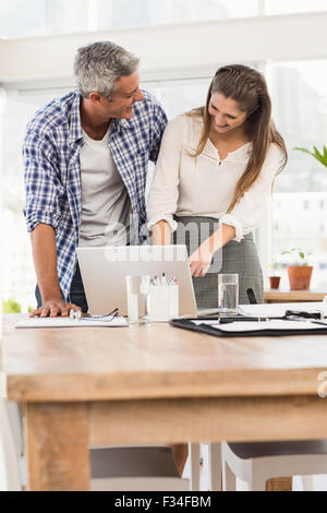 Laughing business colleagues using laptop Stock Photo