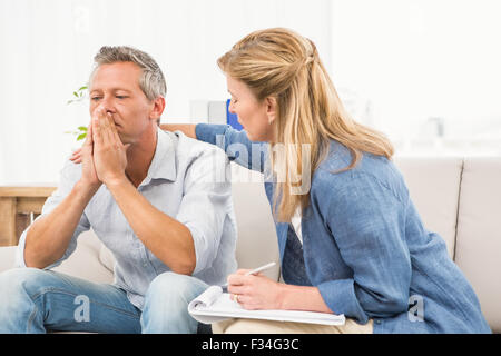 Concerned therapist comforting male patient Stock Photo