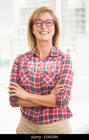 Smiling casual businesswoman with arms crossed Stock Photo