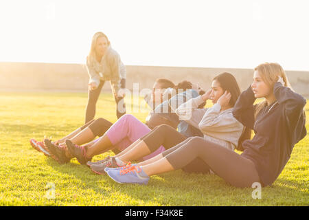 Sporty women doing sit ups during fitness class Stock Photo