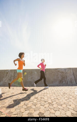 Two sporty women jogging together Stock Photo - Alamy