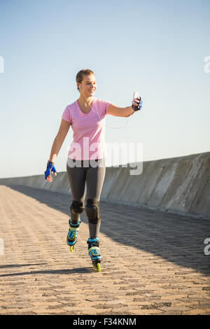 Smiling sporty blonde skating and taking selfies Stock Photo