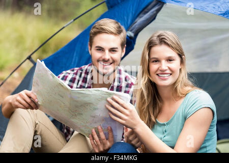 Young pretty hiker couple sitting in a tent looking at camera Stock Photo