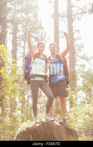 Hikers with backpack standing on top of a mountain with raised hands ...