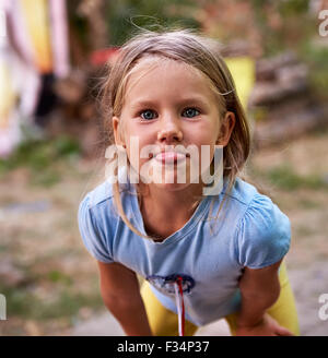 Little girl outdoors teases and puts out her tongue Stock Photo