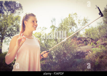 Pretty blonde showing peace sign and taking selfies Stock Photo