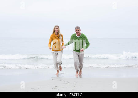 Happy couple holding hands and running Stock Photo