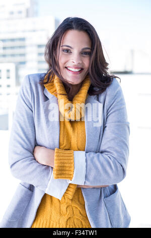 Smiling beautiful brunette standing arms crossed Stock Photo