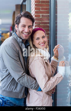Smiling couple embracing and going window shopping Stock Photo