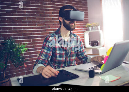 Serious creative businessman using 3D video glasses and laptop Stock Photo