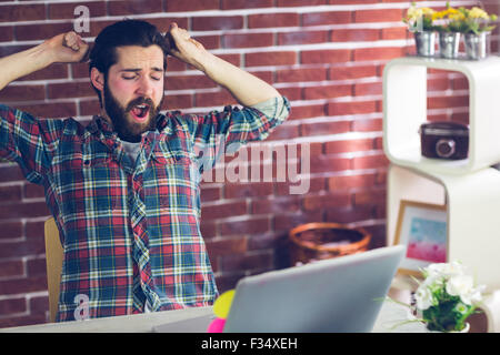 Creative businessman yawning with hands raised Stock Photo
