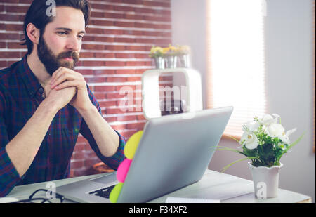 Creative editor with hand clasped using laptop Stock Photo