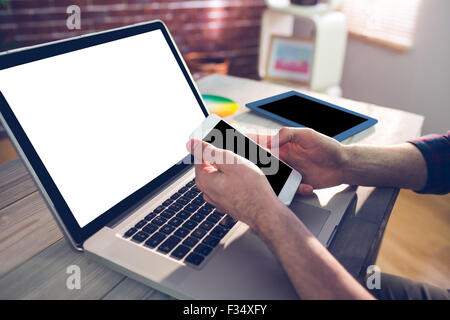 Cropped hand of graphic designer using smartphone and laptop Stock Photo