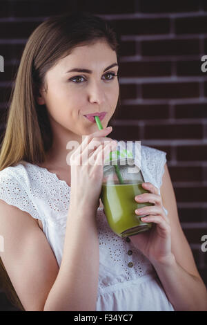 Pretty woman sipping on green juice Stock Photo