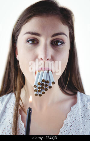 Woman lighting many cigarettes in mouth Stock Photo