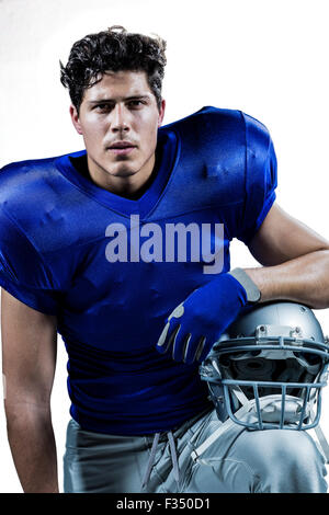 Close-up portrait of serious sportsman holding helmet Stock Photo