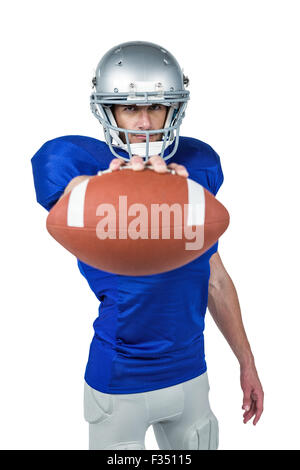 Portrait of American football player showing ball Stock Photo