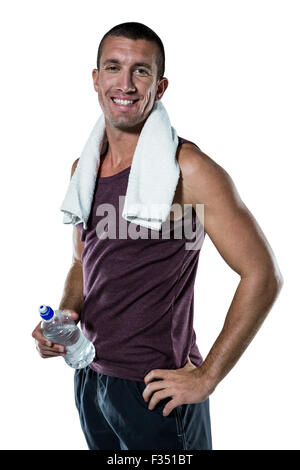 Smiling man with towel on neck holding water bottle Stock Photo