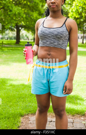 Fit woman measuring her waist Stock Photo