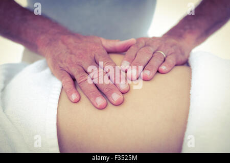 Cropped image of masseur touching pregnant woman tummy Stock Photo
