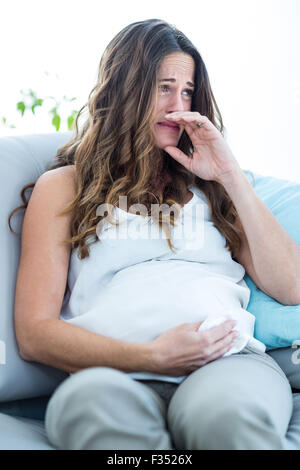 Pregnant woman crying at home Stock Photo