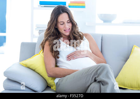 Happy pregnant woman with hands on stomach Stock Photo