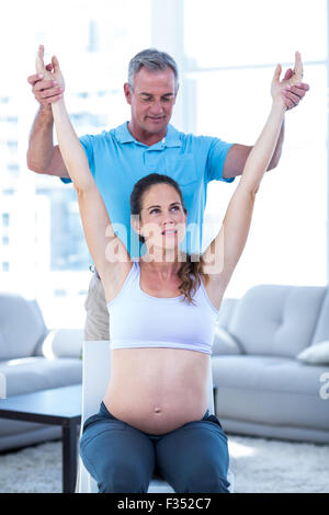 Instructor helping pregnant woman Stock Photo