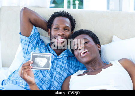 Portrait of happy woman holding ultrasound scan Stock Photo