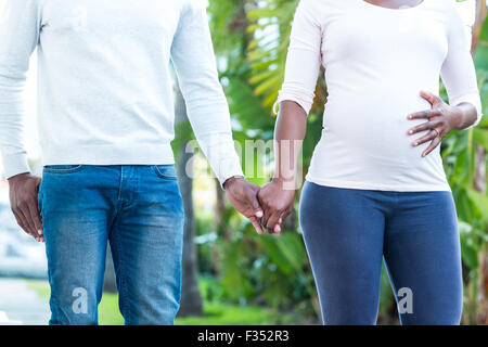 Black couple holding hands while walking by autumn park Stock Photo - Alamy