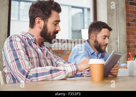 Business people talking to colleague while using digital tablet Stock Photo