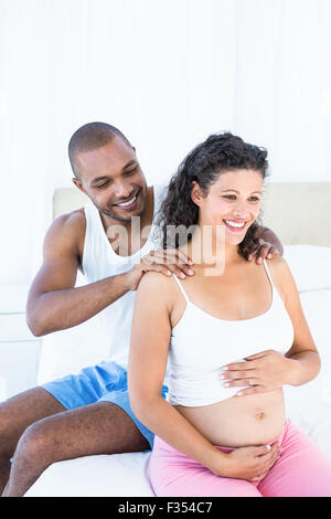 Husband massaging pregnant wife shoulders Stock Photo