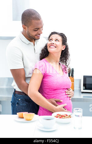 Happy couple standing in kitchen Stock Photo