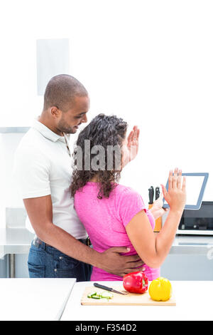 Happy couple gesturing while holding digital tablet Stock Photo