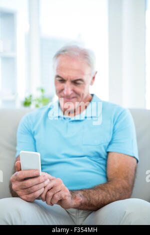 Senior man using smartphone at home Stock Photo