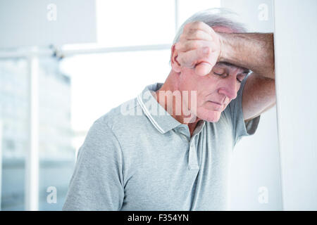 Sad mature man leaning on wall Stock Photo